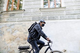 Livreur à vélo en milieu urbain avec masque de protection